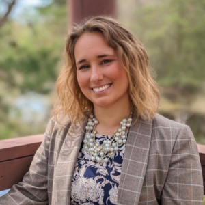 Ashten Rae smiling at the camera in a stripped blazer