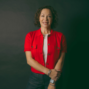Erin Kaplan smiling at the camera in a red jacket 