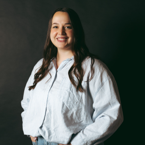 Gabriella Woolpert smiling at the camera in a white button up shirt