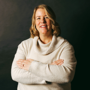 Jen Nance smiling at the camera in a cream colored sweater 
