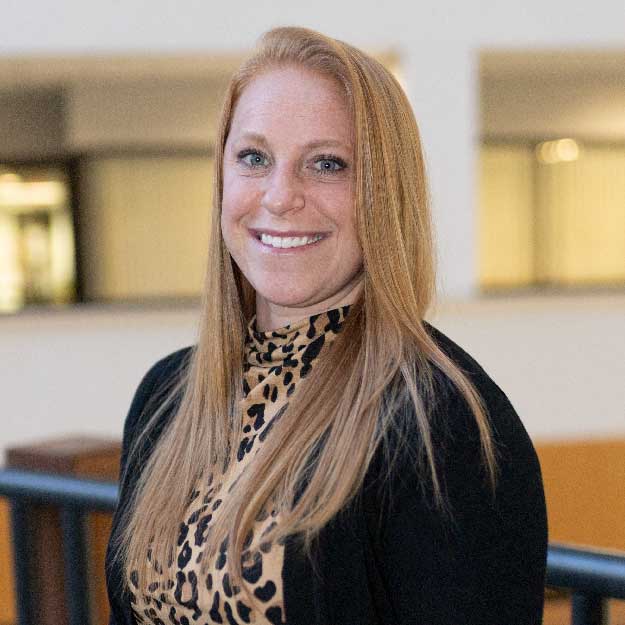 Ashlynn Thomas smiling indoors in a professional setting.