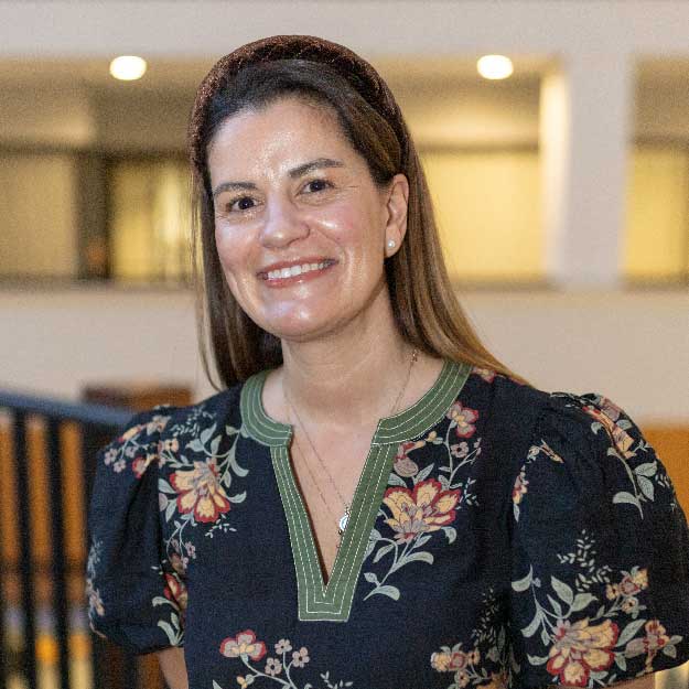 Gina Jasovic smiling indoors in a professional setting.