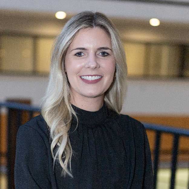 Kristen Ross smiling indoors in a professional setting.
