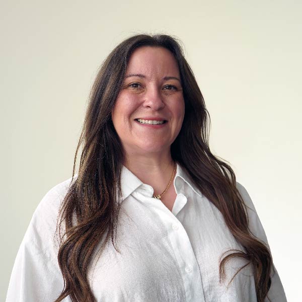 Lauren Fellows sonríe luciendo una camisa blanca abotonada.