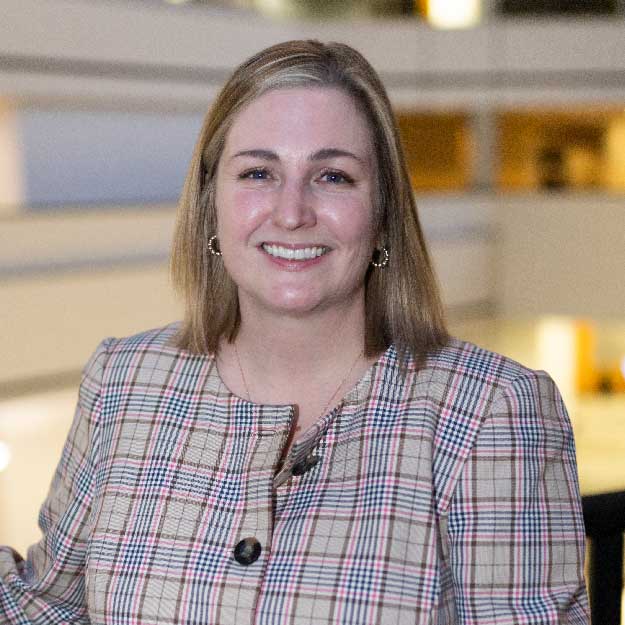 Tara Moore smiling indoors in a professional setting.