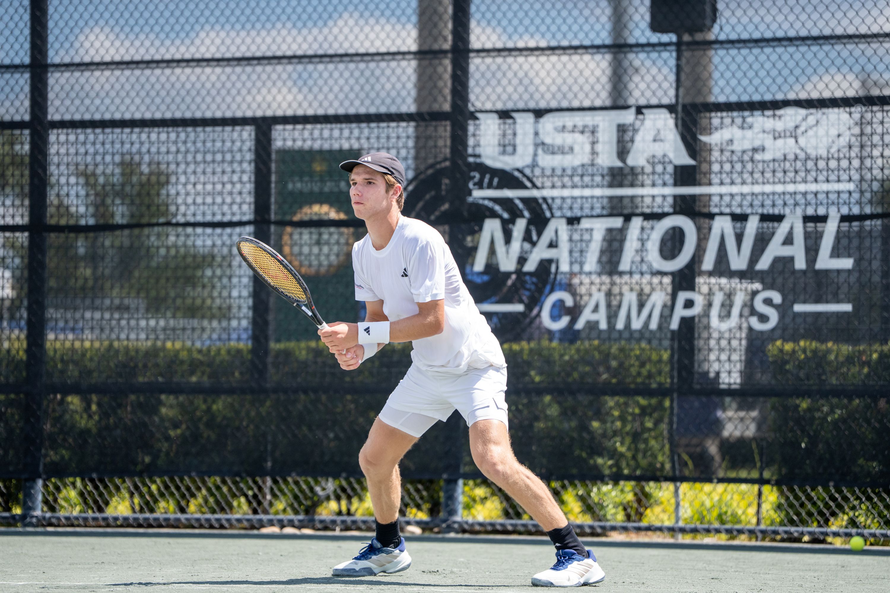 Male tennis player leaping sideways to return a shot during competition, representing the opportunity to advance to higher-level tournaments through wild card entry.