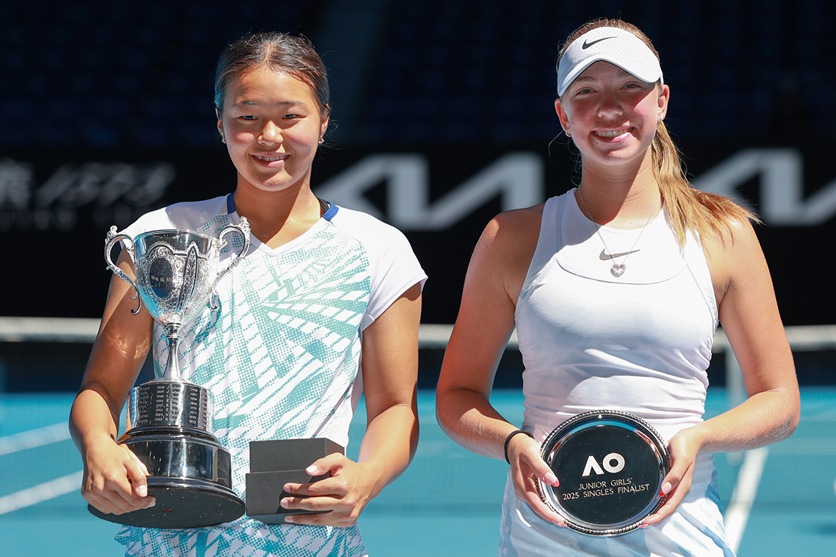 Dos niñas están una al lado de la otra sosteniendo trofeos.